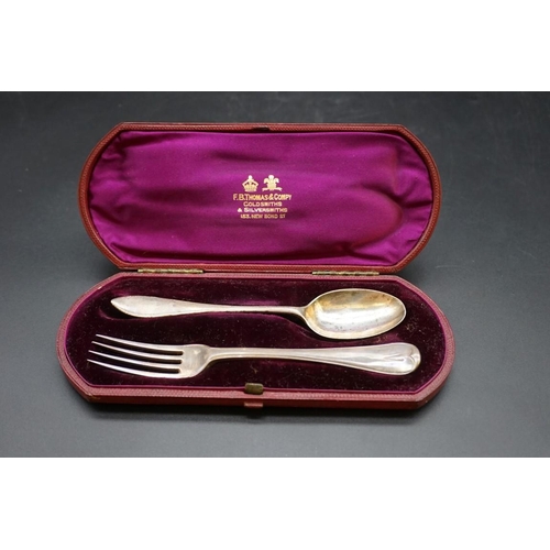 645 - A cased silver christening fork and spoon; together with a cased silver christening spoon; and anoth... 