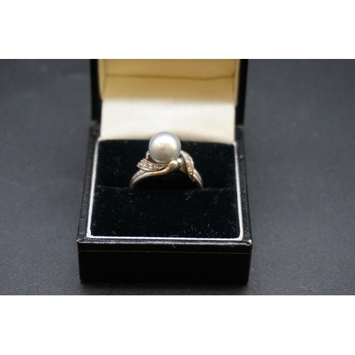 677 - An Arabic unmarked white metal ring, set natural gulf pearl and eight small diamonds, size N.... 