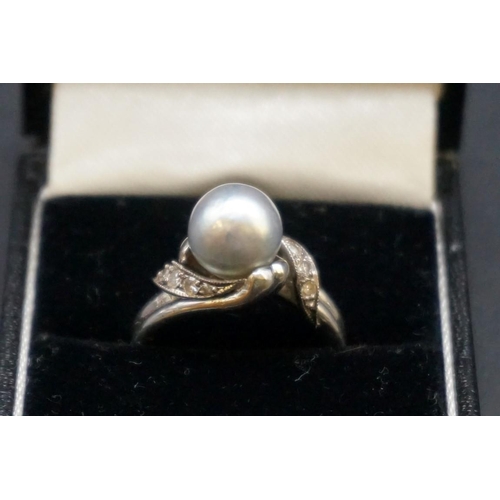 677 - An Arabic unmarked white metal ring, set natural gulf pearl and eight small diamonds, size N.... 