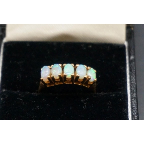 678 - A 9ct gold ring set five oval cabochon opals, size J 1/2, gross weight 2.6g.