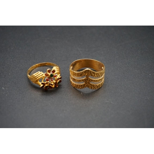 681 - Two yellow metal rings, one decorated coloured enamel, the other having pierced decoration.... 