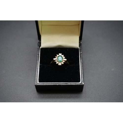 683 - An 18ct gold emerald and diamond cluster ring, set central oval emerald surrounded by ten graduated ... 