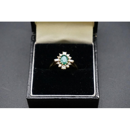 683 - An 18ct gold emerald and diamond cluster ring, set central oval emerald surrounded by ten graduated ... 