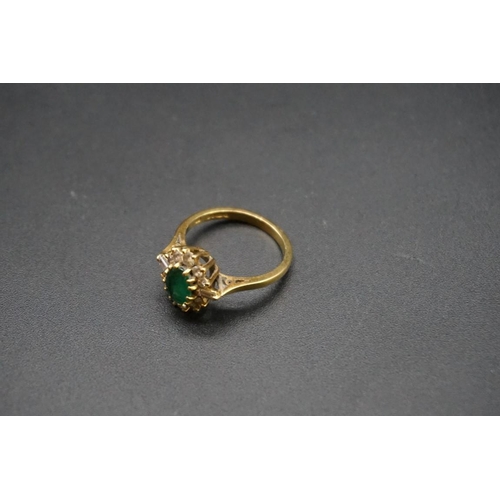 683 - An 18ct gold emerald and diamond cluster ring, set central oval emerald surrounded by ten graduated ... 