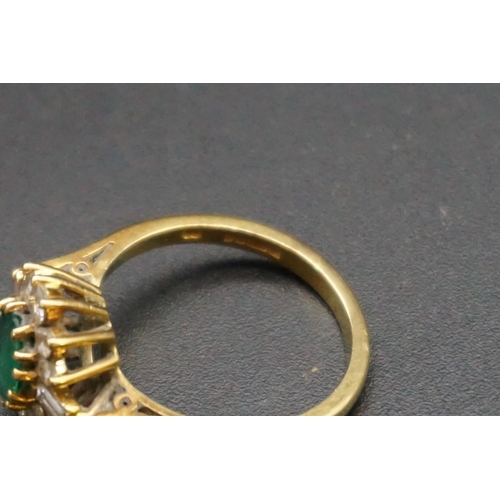 683 - An 18ct gold emerald and diamond cluster ring, set central oval emerald surrounded by ten graduated ... 