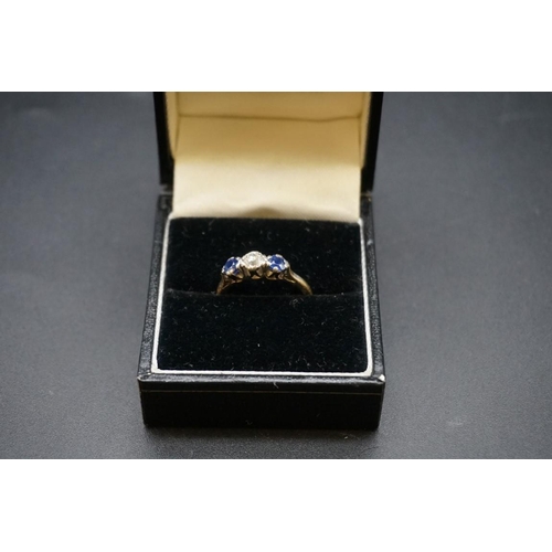 688 - A yellow metal diamond and sapphire three stone ring, the central diamond approx 0.25ct, stamped 18c... 