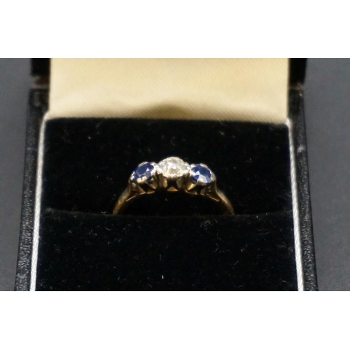 688 - A yellow metal diamond and sapphire three stone ring, the central diamond approx 0.25ct, stamped 18c... 