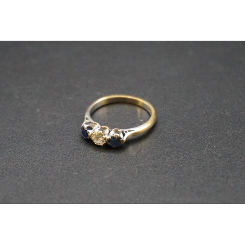 688 - A yellow metal diamond and sapphire three stone ring, the central diamond approx 0.25ct, stamped 18c... 