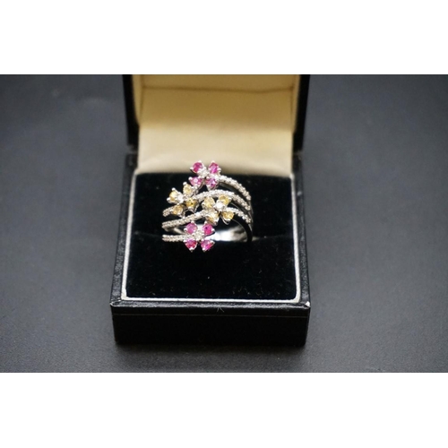 690 - An 18ct gold diamond and gem set floral three band ring, size N1/2.