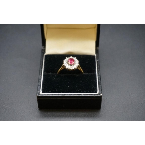 691 - An 18ct gold ruby and diamond cluster ring, set central oval ruby surrounded by ten brilliant cut di... 