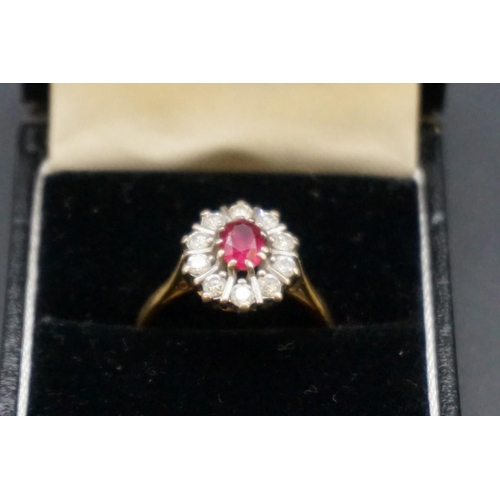 691 - An 18ct gold ruby and diamond cluster ring, set central oval ruby surrounded by ten brilliant cut di... 