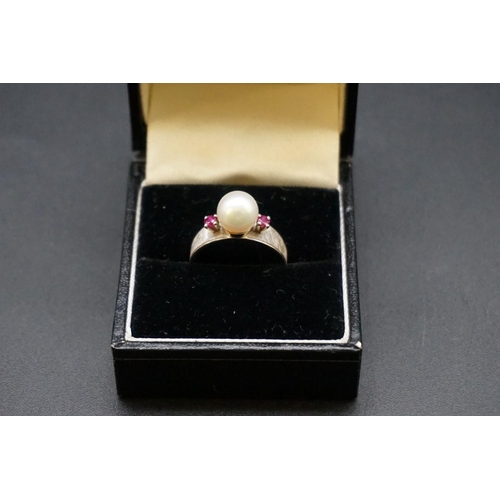 693 - A pearl and ruby three stone ring, stamped 14k, size M1/2.