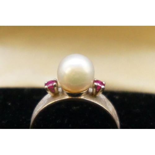 693 - A pearl and ruby three stone ring, stamped 14k, size M1/2.