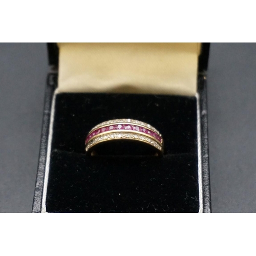 694 - A yellow metal ruby and diamond half eternity ring, size O.