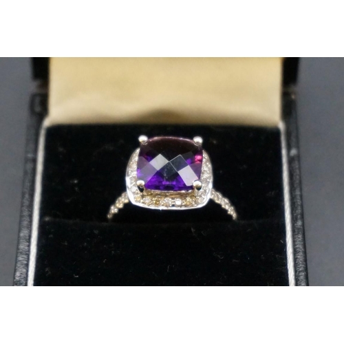 697 - A white metal amethyst and diamond cluster ring, stamped 585 size O.