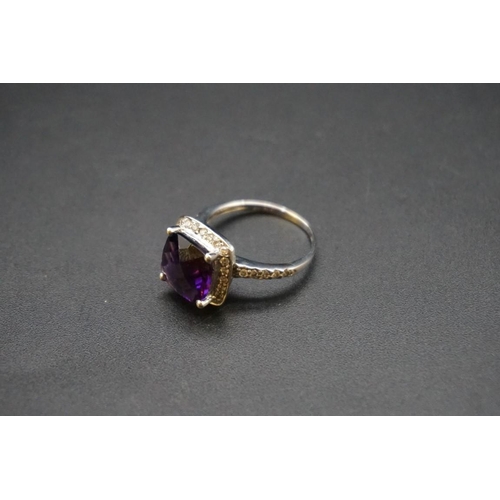 697 - A white metal amethyst and diamond cluster ring, stamped 585 size O.