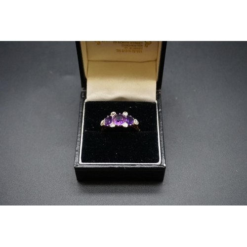 699 - A yellow metal ring set three amethysts and six diamonds, stamped Plat 18ct, size N.... 