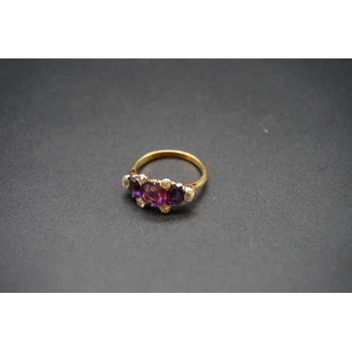 699 - A yellow metal ring set three amethysts and six diamonds, stamped Plat 18ct, size N.... 