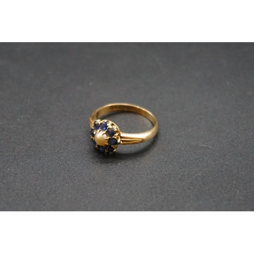 703 - A yellow metal pearl and sapphire cluster ring, stamped 18ct, size P.