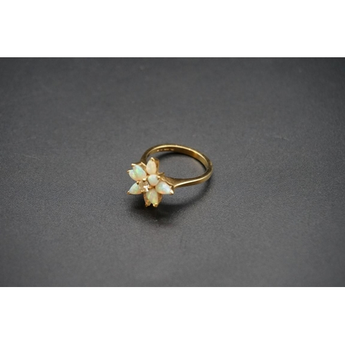 705 - An 18ct gold diamond and opal floral cluster ring, size N1/2; together with a similar pair of ear st... 