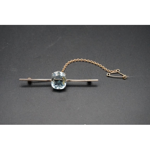 717 - A yellow metal aquamarine bar brooch, stamped 15, the cushion stone approximately 5.6ct, 61mm gross ... 