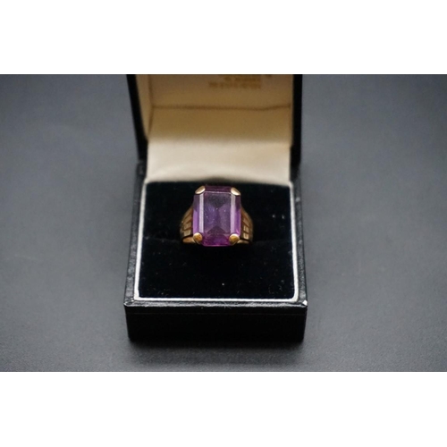 727 - A yellow metal ring set rectangular synthetic Alexandrite, size M.