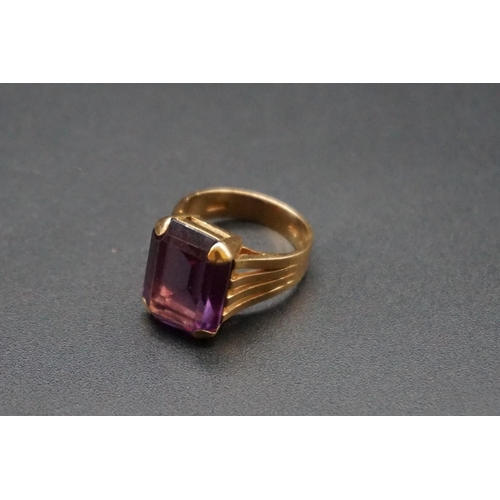 727 - A yellow metal ring set rectangular synthetic Alexandrite, size M.