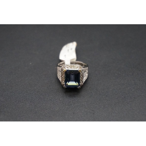 728 - A 14ct white gold ring, set rectangular facetted blue gemstone and small diamonds, size N.... 