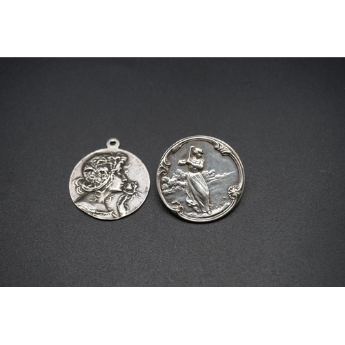 745 - A white metal golf badge, 28mm diameter; together with another Art Nouveau white metal pendant, stam... 