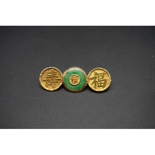 746 - A Chinese yellow metal and jade brooch, stamped K.H 18, 4.5cm.