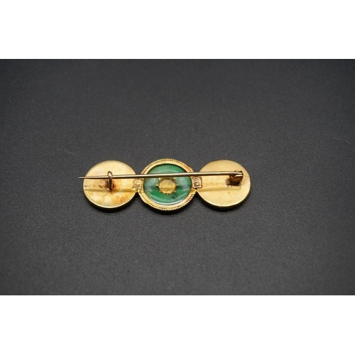 746 - A Chinese yellow metal and jade brooch, stamped K.H 18, 4.5cm.