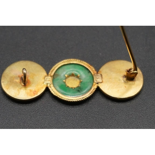 746 - A Chinese yellow metal and jade brooch, stamped K.H 18, 4.5cm.