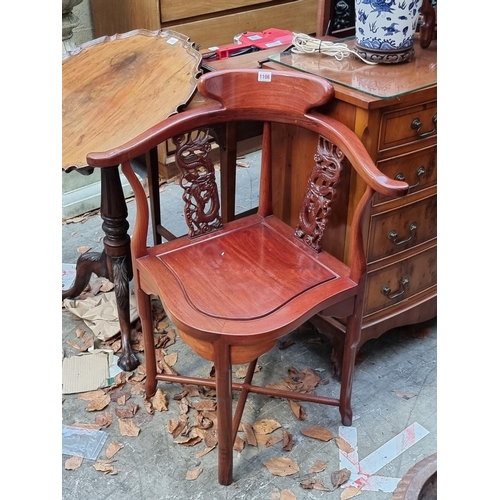 1106 - A Chinese carved hardwood cornet elbow chair. 