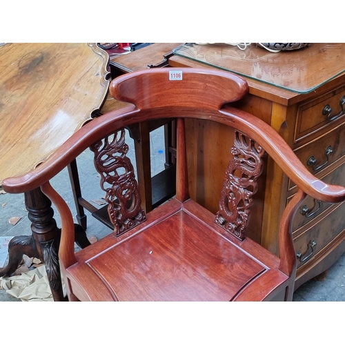 1106 - A Chinese carved hardwood cornet elbow chair. 