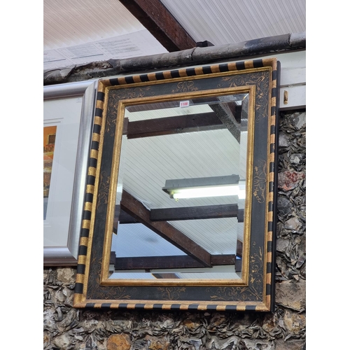 1108 - An ebonized and parcel gilt framed rectangular wall mirror, 79.5 x 64.5cm.