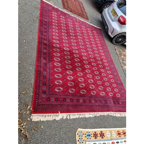 1080 - A large Bokhara carpet, on a red ground, 363 x 274cm.