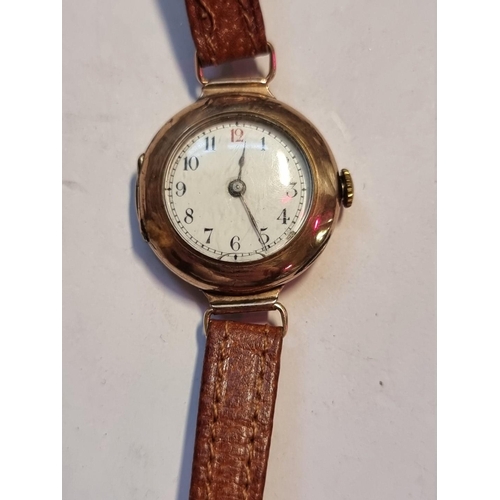 990 - A 9ct gold ladies manual wind wristwatch, on brown leather strap.