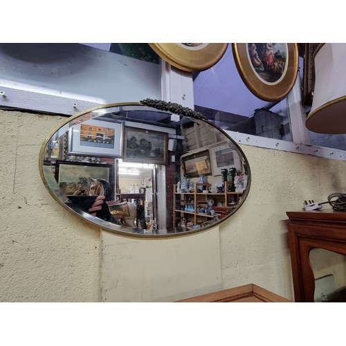 1139 - Two 1930s brass framed oval wall mirrors, largest 52.5 x 73cm. (2)