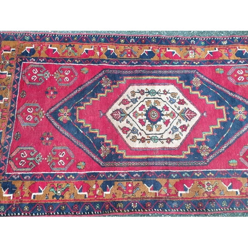 1013 - A Persian red ground rug, 227 x 113cm.