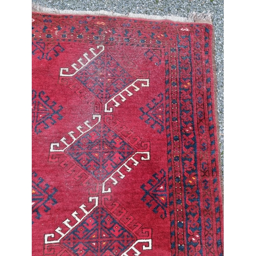 1015 - A Tribal rug, on a red ground, 168cm x 120cm.