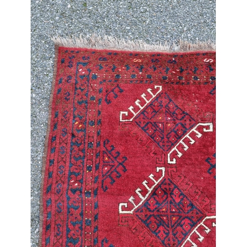 1015 - A Tribal rug, on a red ground, 168cm x 120cm.