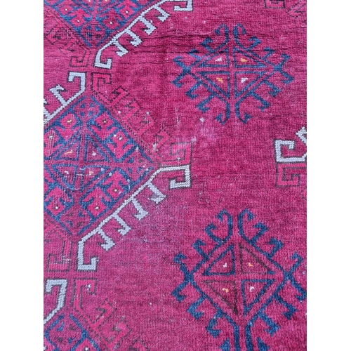 1015 - A Tribal rug, on a red ground, 168cm x 120cm.