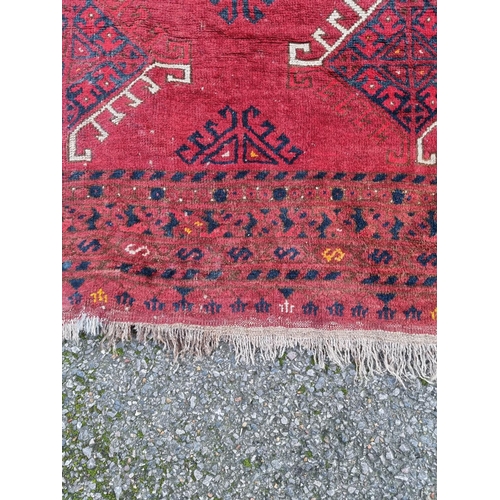 1015 - A Tribal rug, on a red ground, 168cm x 120cm.