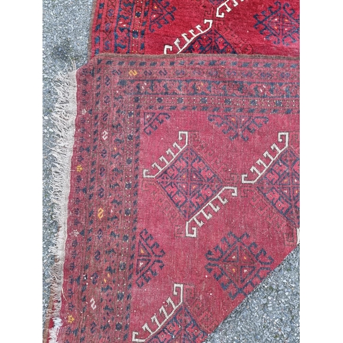 1015 - A Tribal rug, on a red ground, 168cm x 120cm.