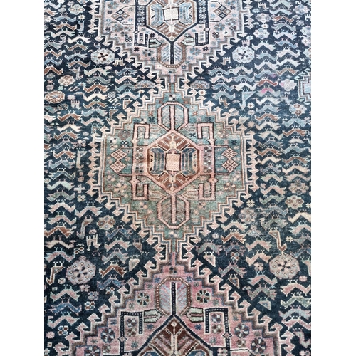 1016 - A Persian rug, having three central diamond medallions, central field decorated with geometric desig... 