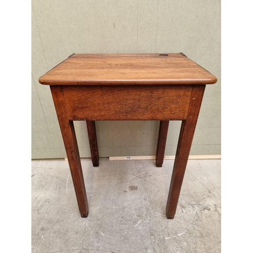 1023 - An old oak school desk, with hinged top, 56cm wide. 