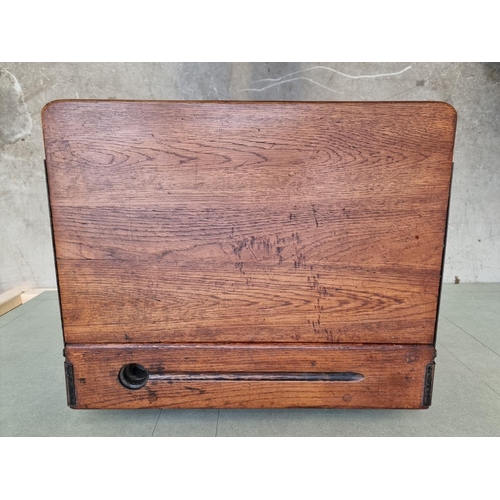 1023 - An old oak school desk, with hinged top, 56cm wide. 