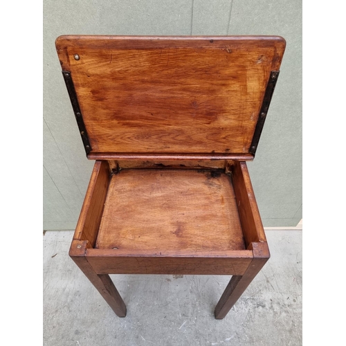 1023 - An old oak school desk, with hinged top, 56cm wide. 