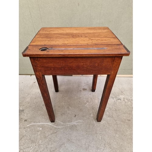 1023 - An old oak school desk, with hinged top, 56cm wide. 