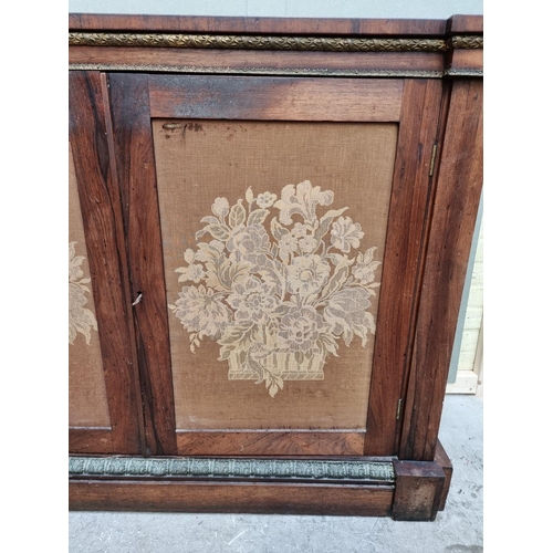 1030 - A George IV rosewood and gilt brass side cabinet, with fabric panel doors, 132.5cm wide.... 